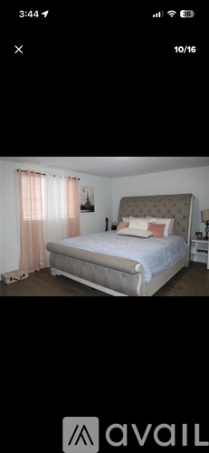 A bed with a white headboard and a pink pillow is in the image.