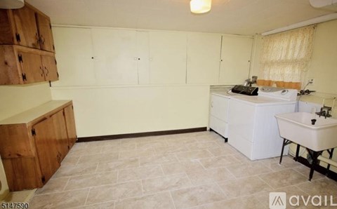 A bathroom with a white sink and a wooden cabinet.