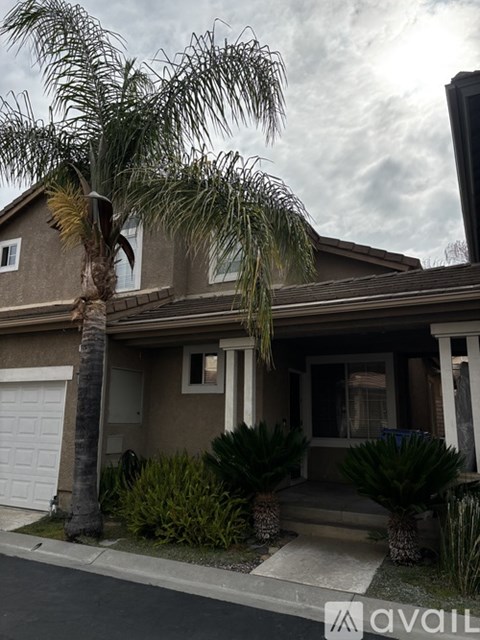 A house with a palm tree in front.