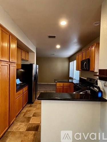 A kitchen with wooden cabinets and a black countertop.