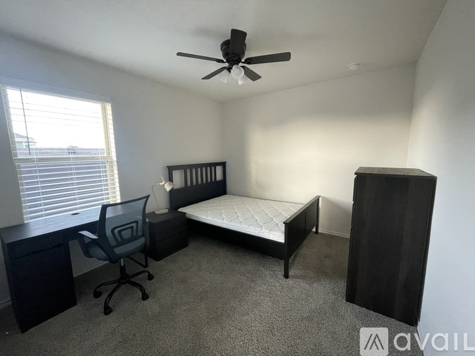 A bedroom with a bed, desk, and chair.