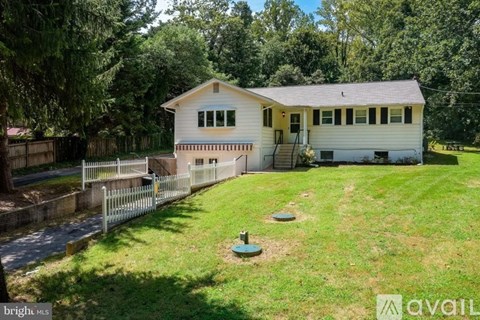 A house with a white fence and a green lawn.