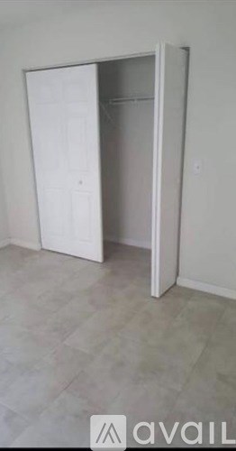 A white wardrobe with the door open in a room.