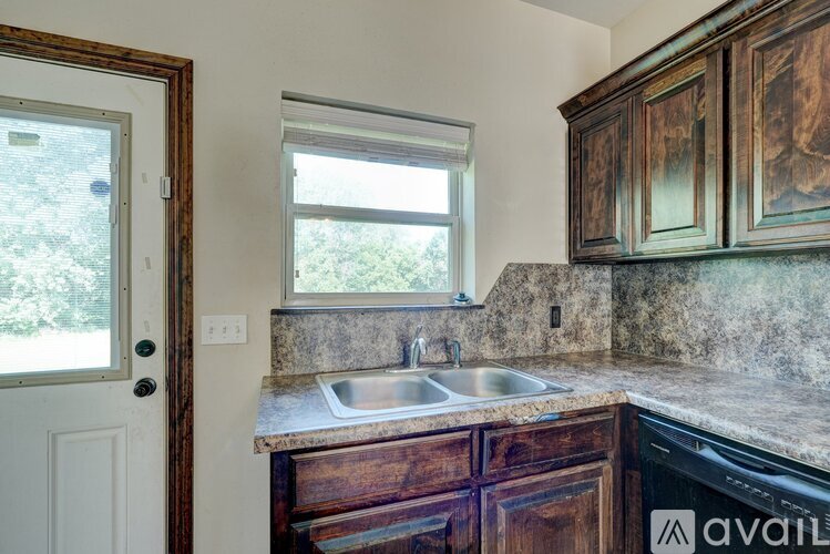 A kitchen with wooden cabinets and a marble countertop.