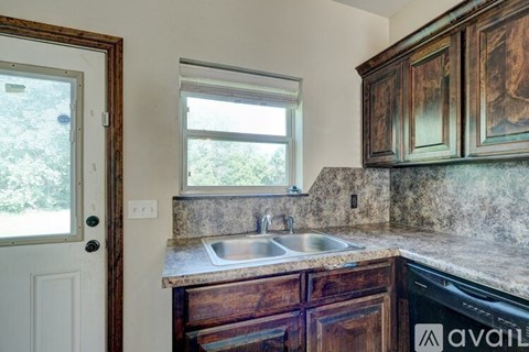 A kitchen with wooden cabinets and a marble countertop.