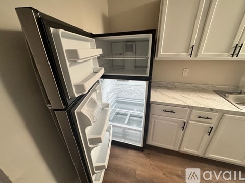 A modern kitchen with a refrigerator and cabinets.