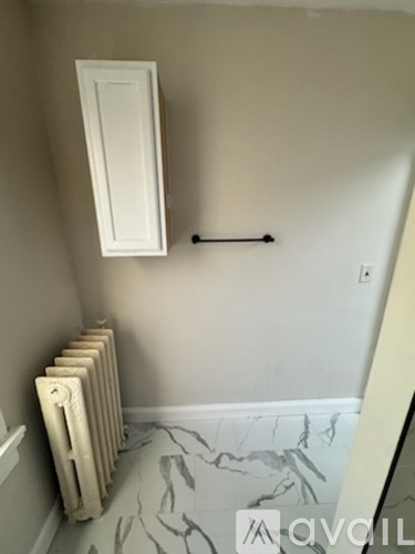 A room with a radiator and a door on the wall.