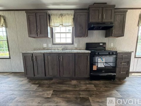 A kitchen with wooden cabinets and a black stove top oven.