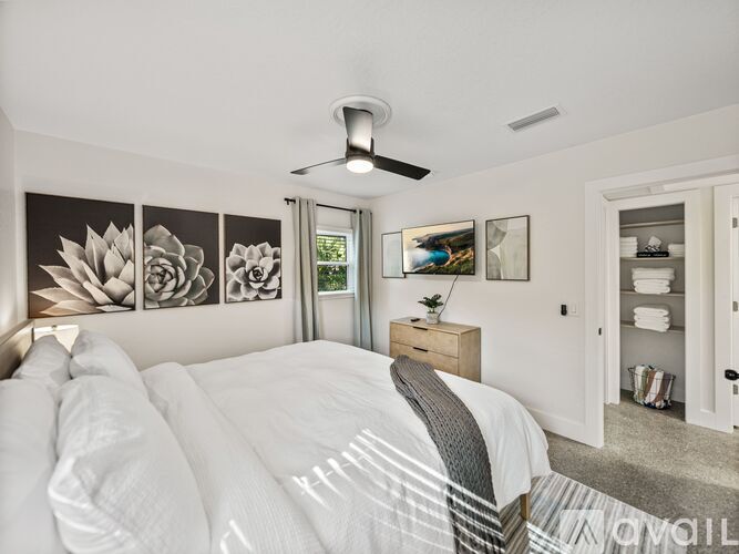 A bedroom with a bed, dresser, and a ceiling fan.