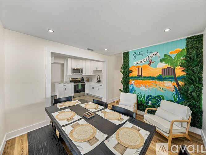 A kitchen with a table and chairs in front of a mural.