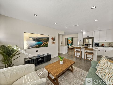 A living room with a couch, a coffee table, and a painting on the wall.