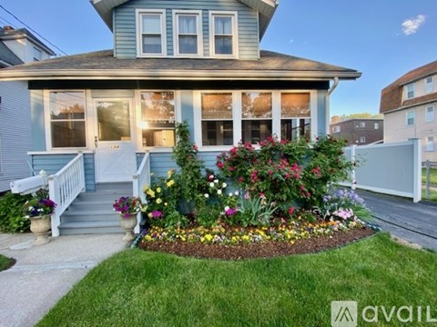 A house with a front yard garden and a white fence.