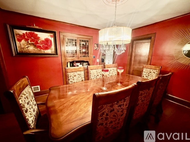 A dining room with a wooden table and chairs.