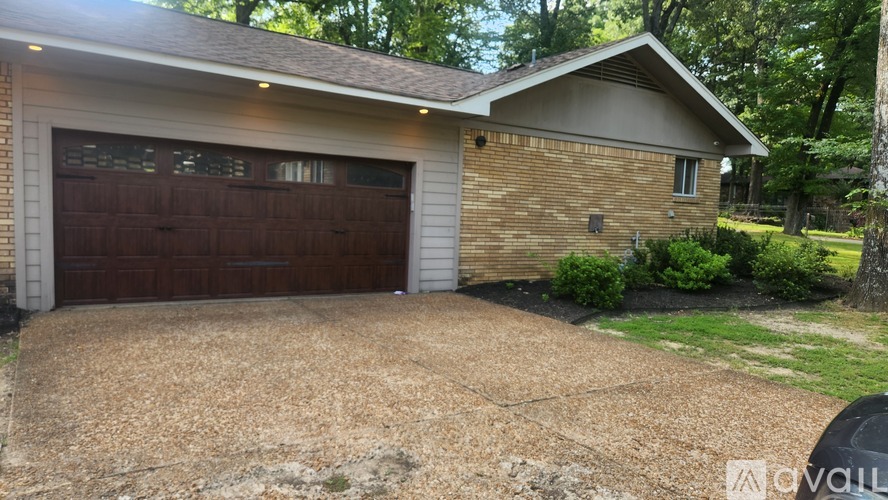 A house with a brown garage door and a gravel driveway.
