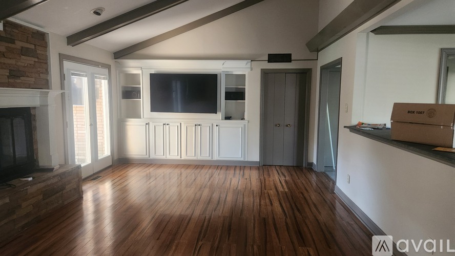 A living room with wooden floors and a television.