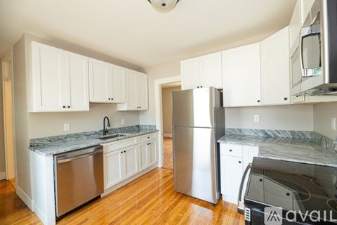 A kitchen with white cabinets and a granite countertop.