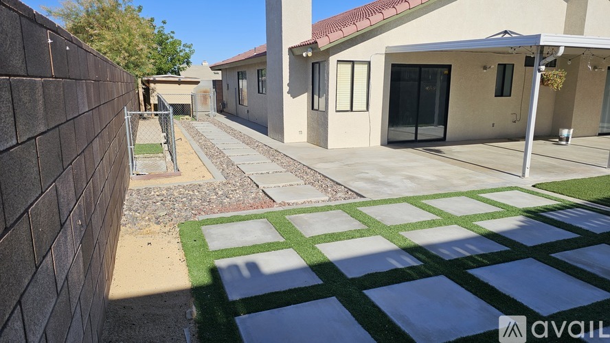 A modern house with a black fence and a green and white tiled walkway.