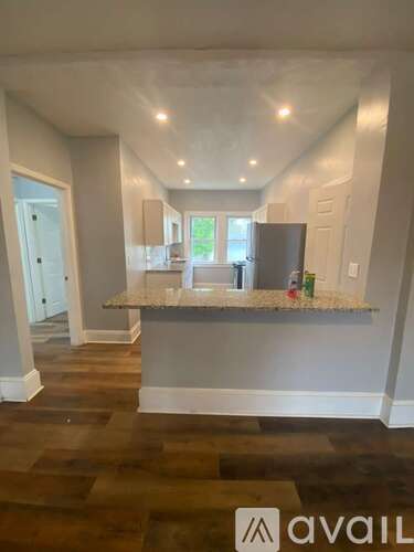 A kitchen with a granite countertop and a refrigerator.