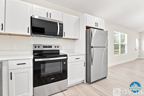 A kitchen with white cabinets and a stainless steel refrigerator.
