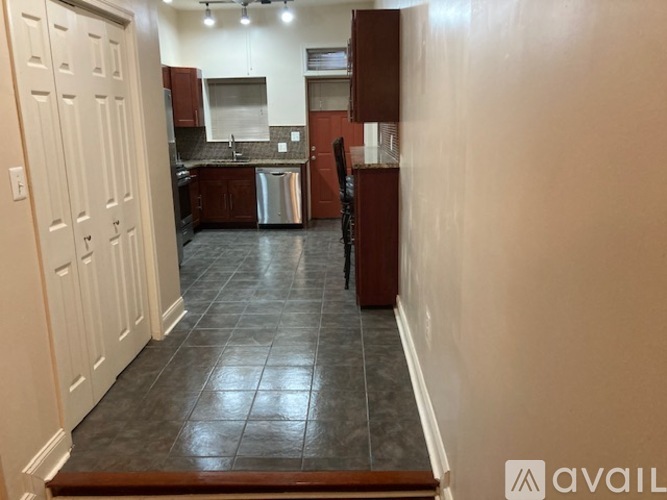 A kitchen with brown cabinets and a black tile floor.