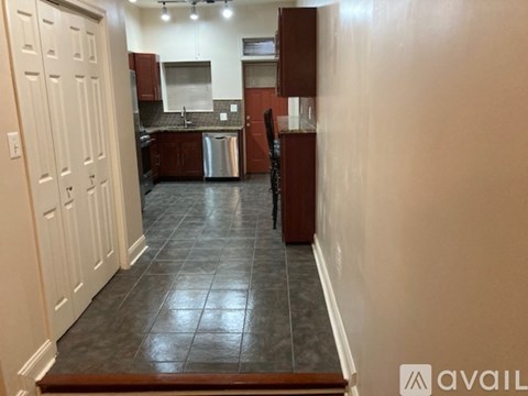 A kitchen with brown cabinets and a black tile floor.