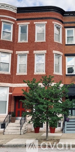A tree in front of a red building.