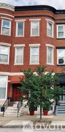 A tree in front of a red building.