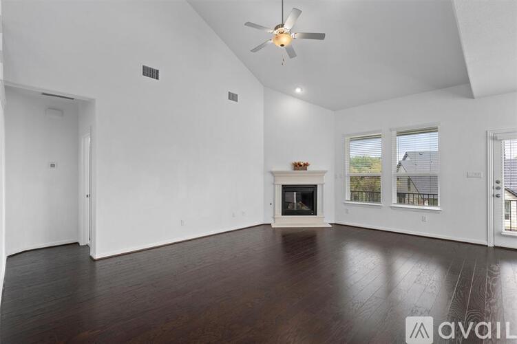 A spacious living room with a fireplace and hardwood floors.
