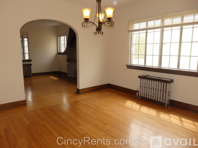 A room with wooden floors and a window with blinds.