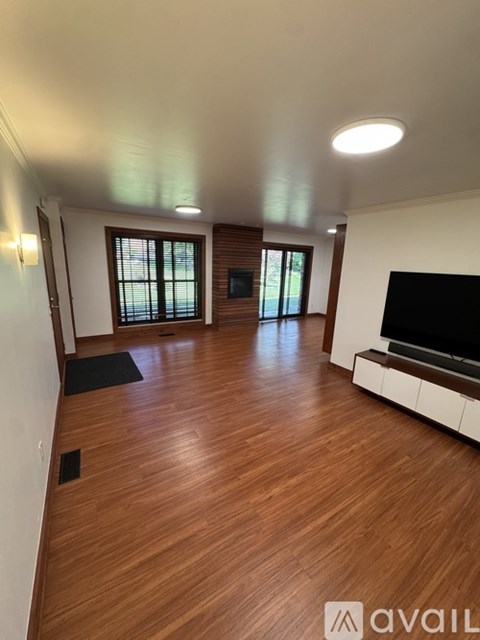 A living room with wooden floors and a flat screen TV.