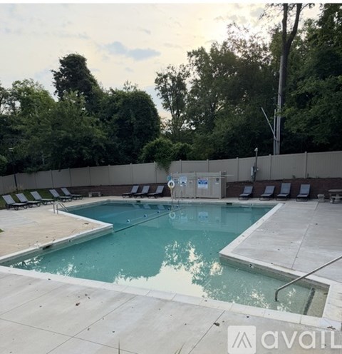 A pool with a blue tinted water and a white tiled floor.