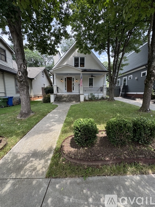 A house with a front yard and a flag on the porch.