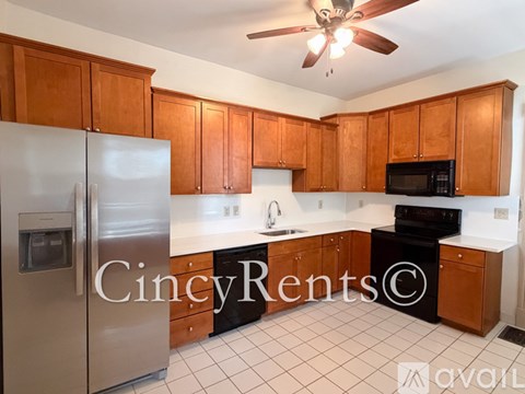 A kitchen with wooden cabinets and a stainless steel refrigerator.