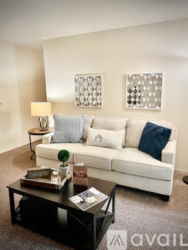A living room with a white couch and a black coffee table.