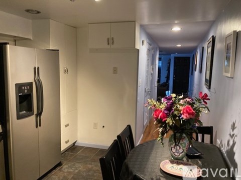 A kitchen with a fridge, table and chairs.