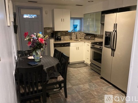 A kitchen with a table set for two and a fridge on the right.