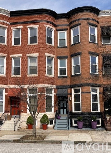 A red brick building with a tree in front.