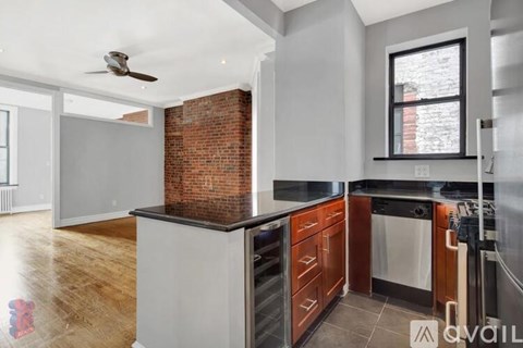 A kitchen with a brick wall and wooden cabinets.
