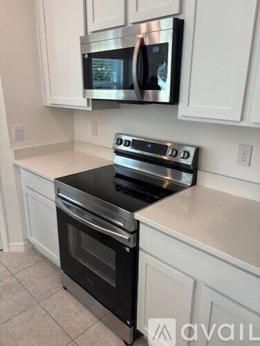 A kitchen with a stainless steel oven and microwave above it.