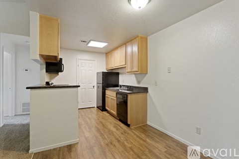A kitchen with wooden cabinets and a black countertop.