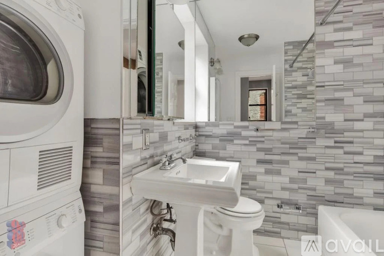 A modern bathroom with a washing machine built into the wall.