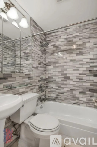 A bathroom with a toilet, sink, and a glass shower door.