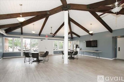 A spacious room with wooden beams and a dining table set up.