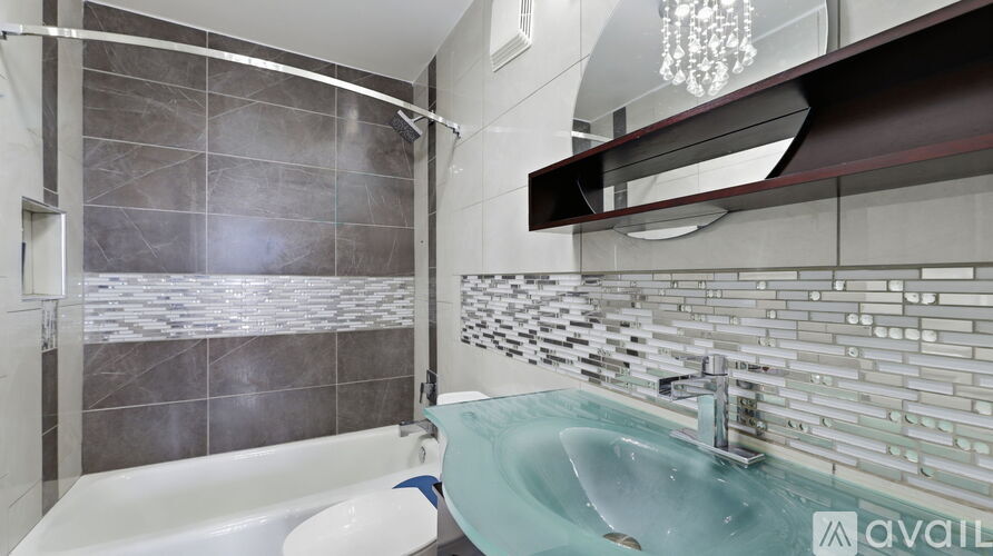 A modern bathroom with a glass shower enclosure and a white bathtub.