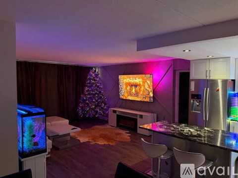 A living room with a TV, a couch, and a Christmas tree.