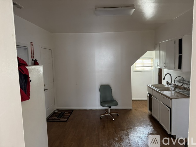 A kitchen with a chair and a sink.