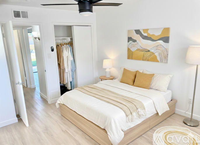 A bedroom with a large bed and a ceiling fan.