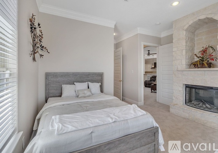 A bedroom with a large bed and a fireplace.