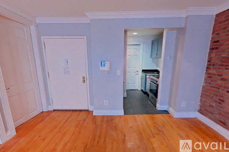 A room with wooden floors and a brick wall.