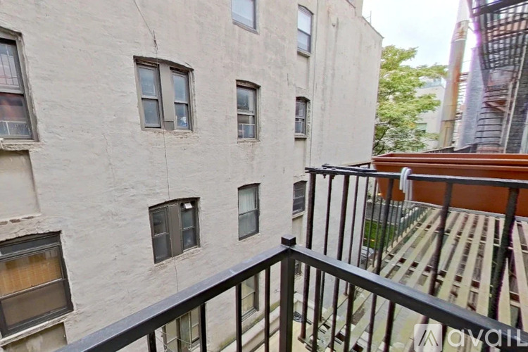 A balcony with a railing overlooks a building with windows.